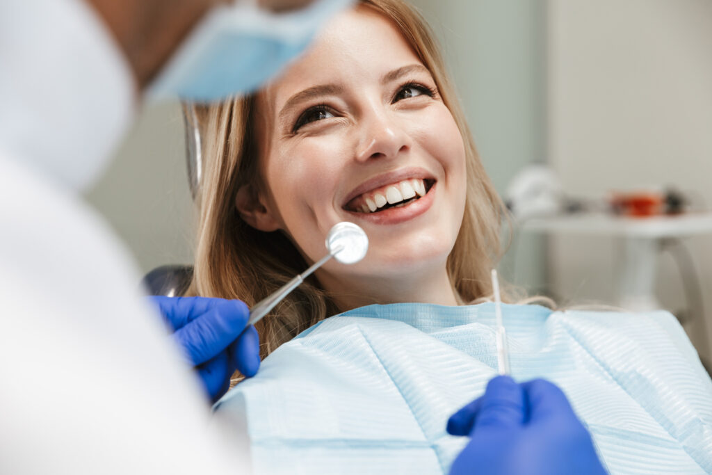 Lakeside smile pretty young woman sitting in dental chair at medical center while professional doctor will cleaning her teeth