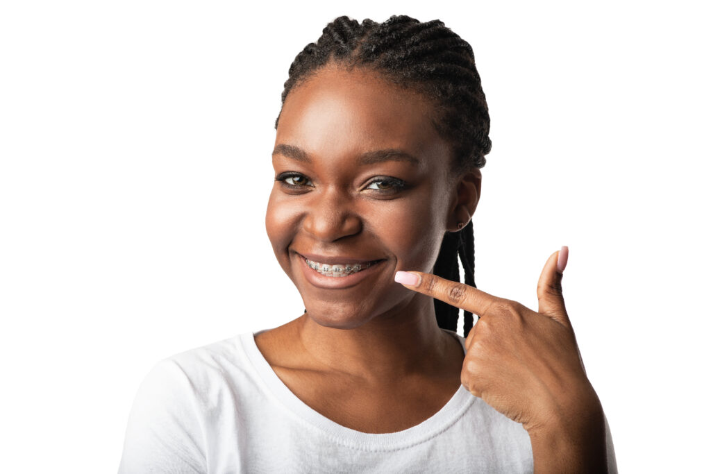 Lakeside smile Straight Teeth. African Girl Pointing Finger At Braces And Smile