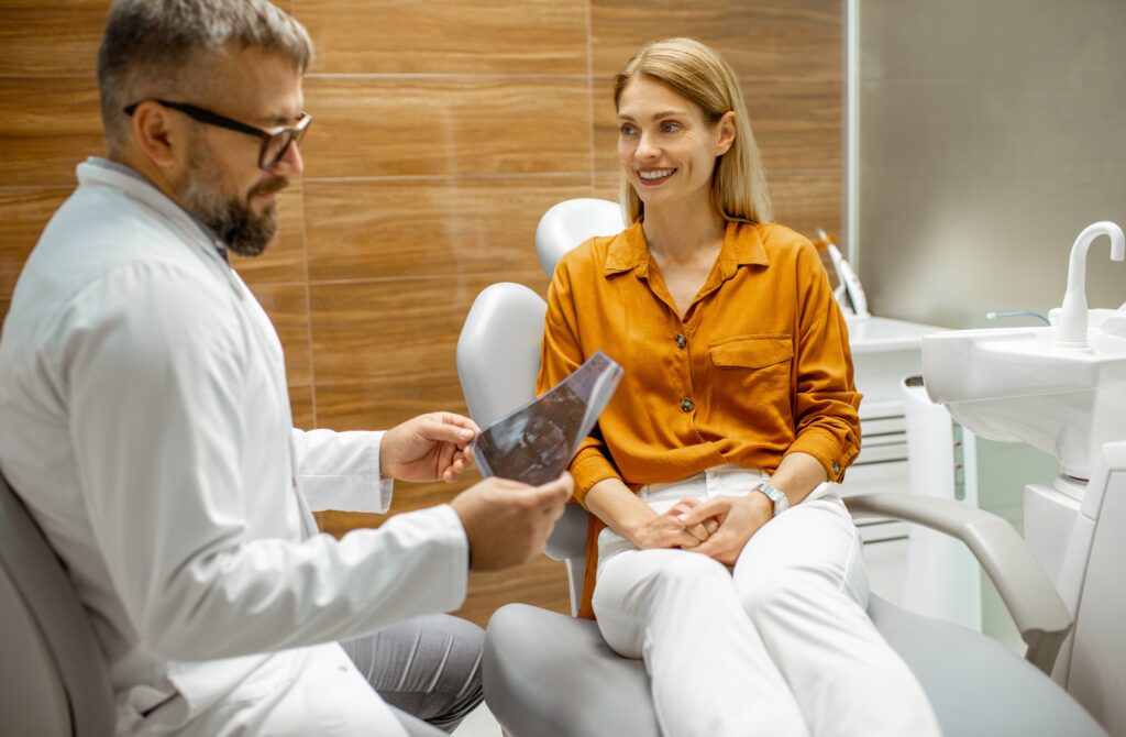 Lakeside smile Beautiful woman as a patient with senior dentist during a medical consultation at the dental office, doctor showing x-ray image of a jaw Surgical