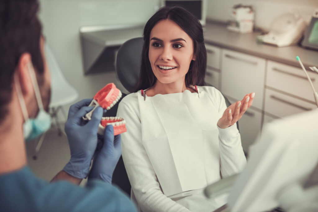 Lakeside smile Beautiful woman is sitting in dentist's chair and listening to the doctor