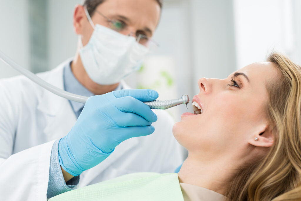 Lakeside smile Female patient at dental procedure using dental drill in modern dental clinic.